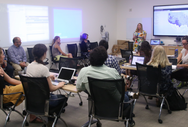 Sudents sitting in chairs in a classroom, facing the instructor